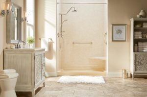 A tastefully appointed bathroom has a walk-in shower with a light-pink wall system and base.