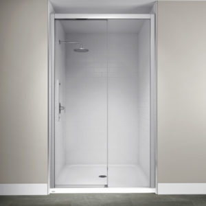 An elegant walk in shower with white tile and a glass door with a silver frame.